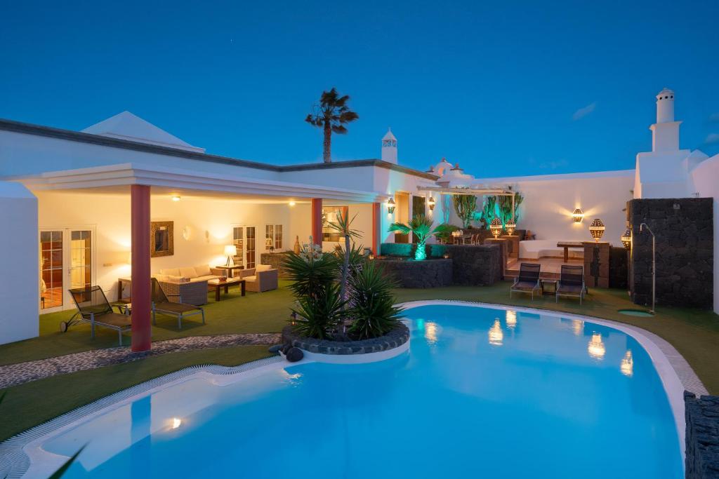 a villa with a swimming pool at night at Finca del Moral in Tinajo