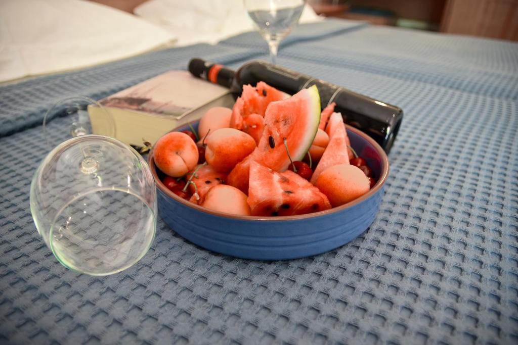 a bowl of fruit on a table next to a glass at Aristotelis Hotel in Stavros