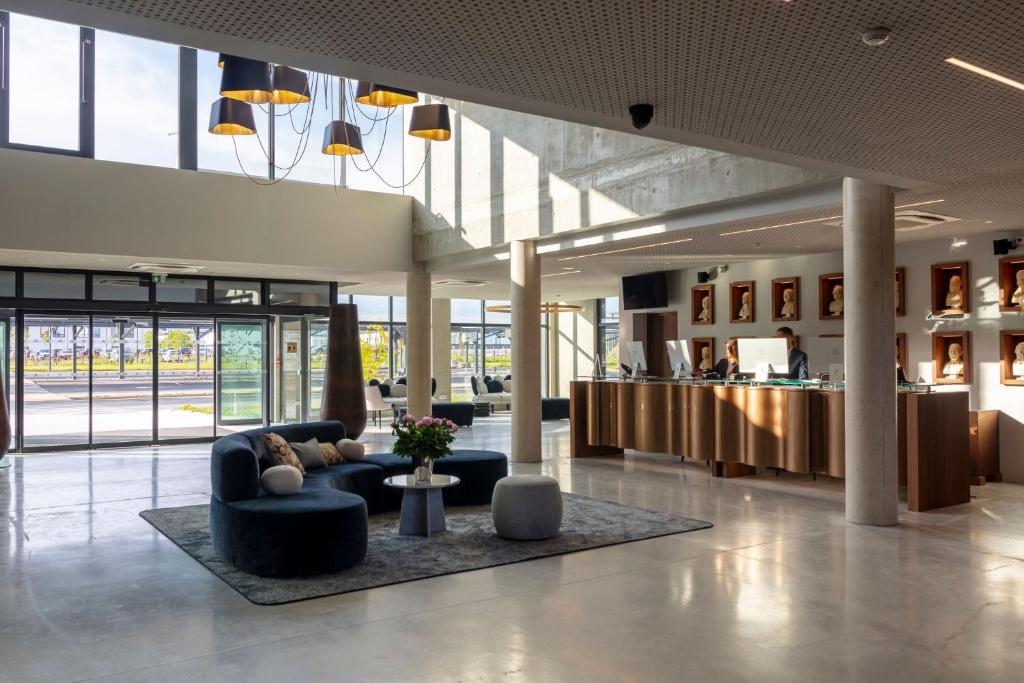 a lobby with couches and tables in a building at Ki Space Hotel & Spa - près de Disneyland Paris in Serris