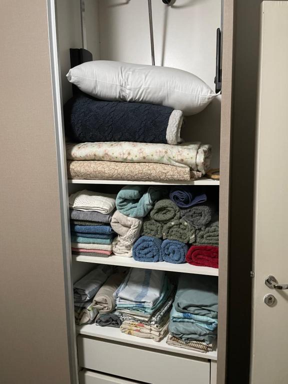 a closet with towels and blankets and a pillow at Casa centro Falls in Foz do Iguaçu