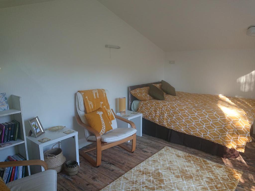 - une chambre avec un lit et une chaise dans l'établissement 2 Bed Cottage Dog Child Friendly 15min walk to beach, à Ederyn