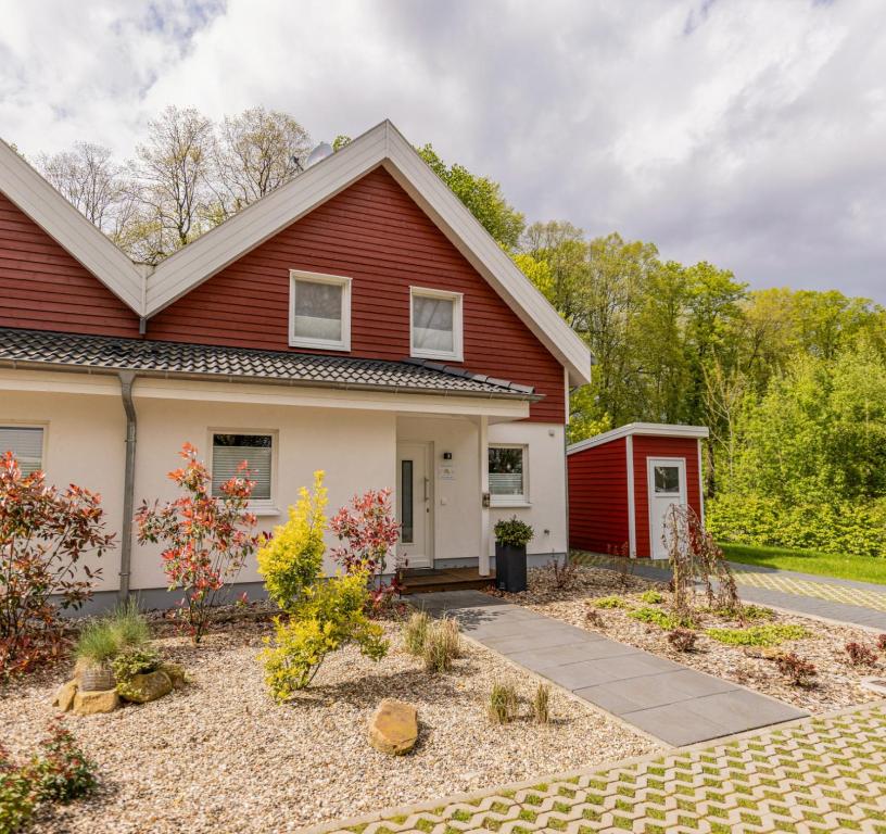 a red house with a garden in front of it at Villa Verde - Nordhorn in Nordhorn