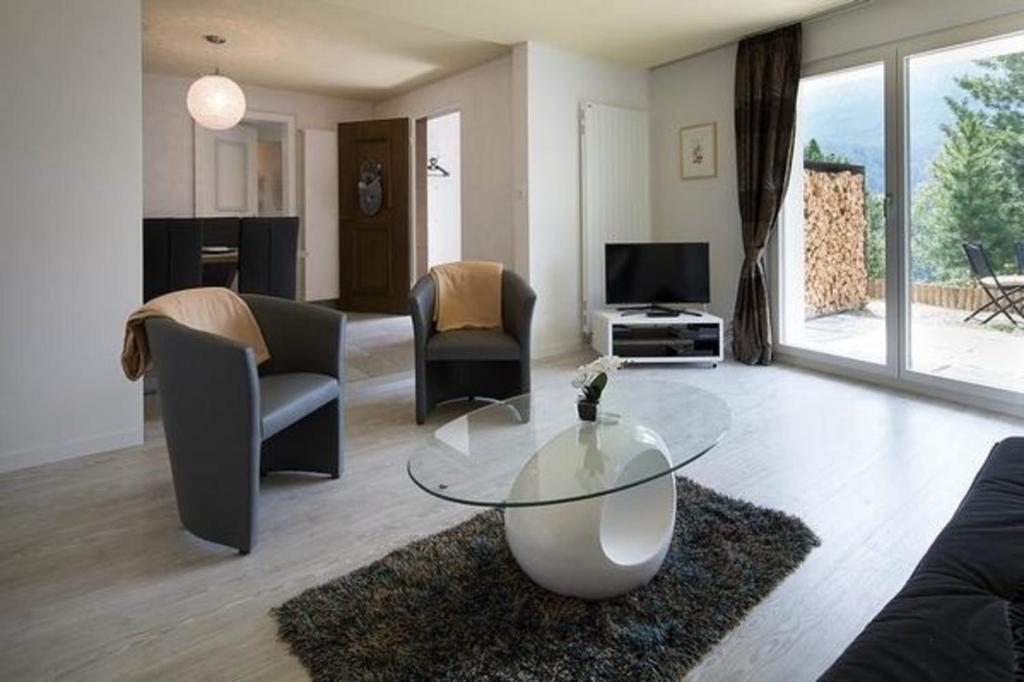a living room with a glass table and chairs at Chasa Diala, sonnig und schönste Aussicht, Wohnung Sirena in Scuol