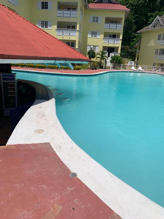 una gran piscina frente a un edificio en Cozy Apartment at Mystic Ridge Ocho Rios, en Ocho Ríos