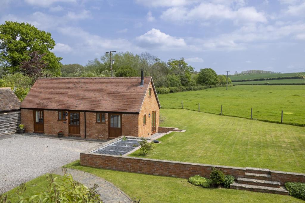 a small brick house with a large yard at The Stables in Mickleton