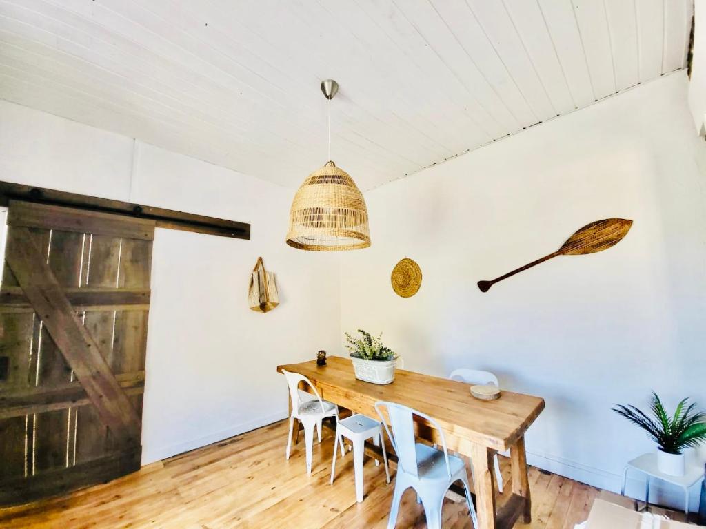 une salle à manger avec une table et des chaises en bois dans l'établissement Entre pin et ocean carcans ville, à Carcans