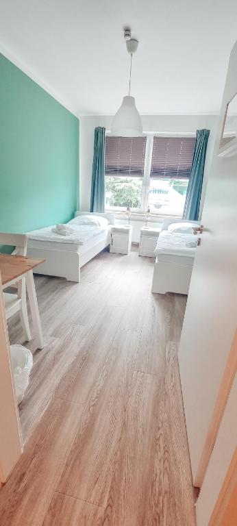 Großes Zimmer mit 2 Betten und einem Tisch in der Unterkunft Zweibettzimmer "Grün" in zentraler Lage in Bremen