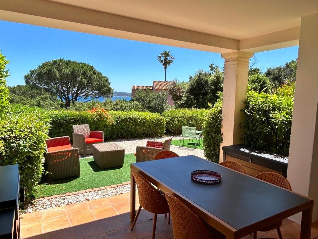 d'une terrasse avec une table et des chaises ainsi que d'un jardin. dans l'établissement Les Restanques vue mer Bastide rez jardin 3021, à Grimaud