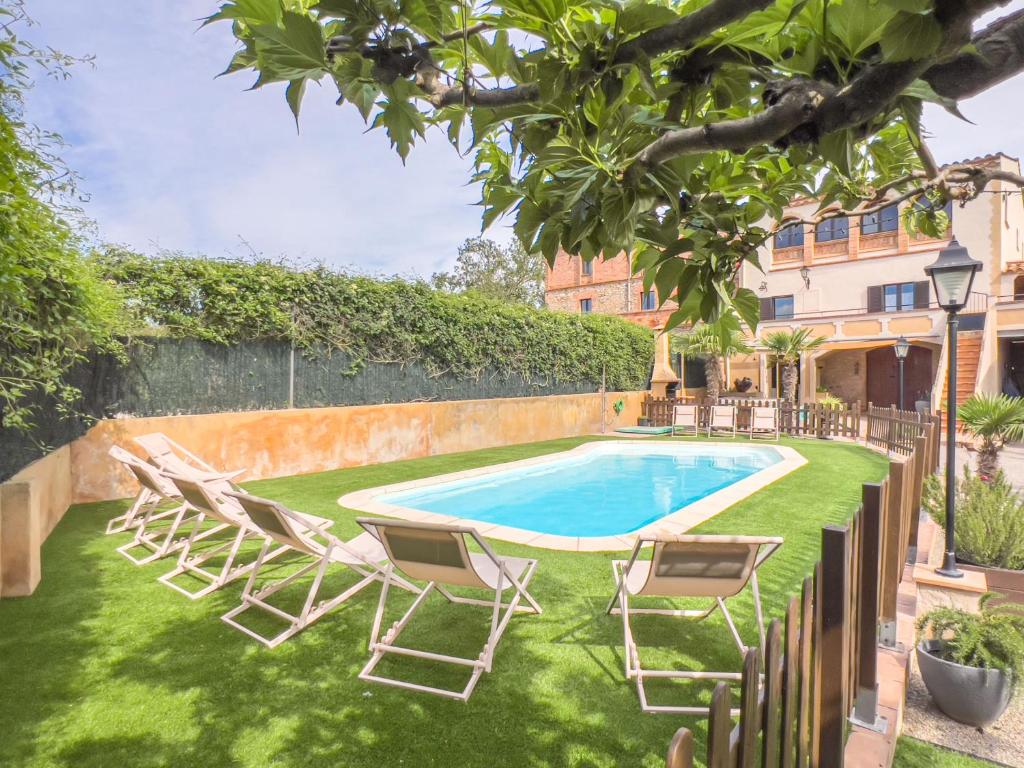 un patio con tumbonas y una piscina en Private country house with pool and barbecue en Girona