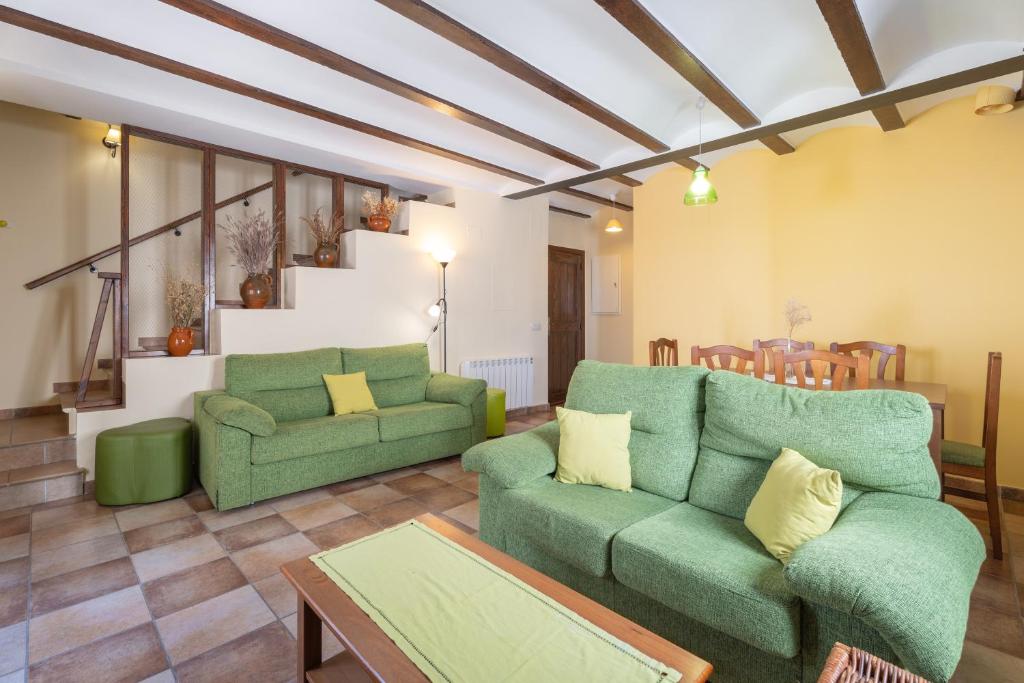 una sala de estar con 2 sofás verdes y una mesa. en Apartamento Casa El Cojo 2b, en Alcalá de la Selva