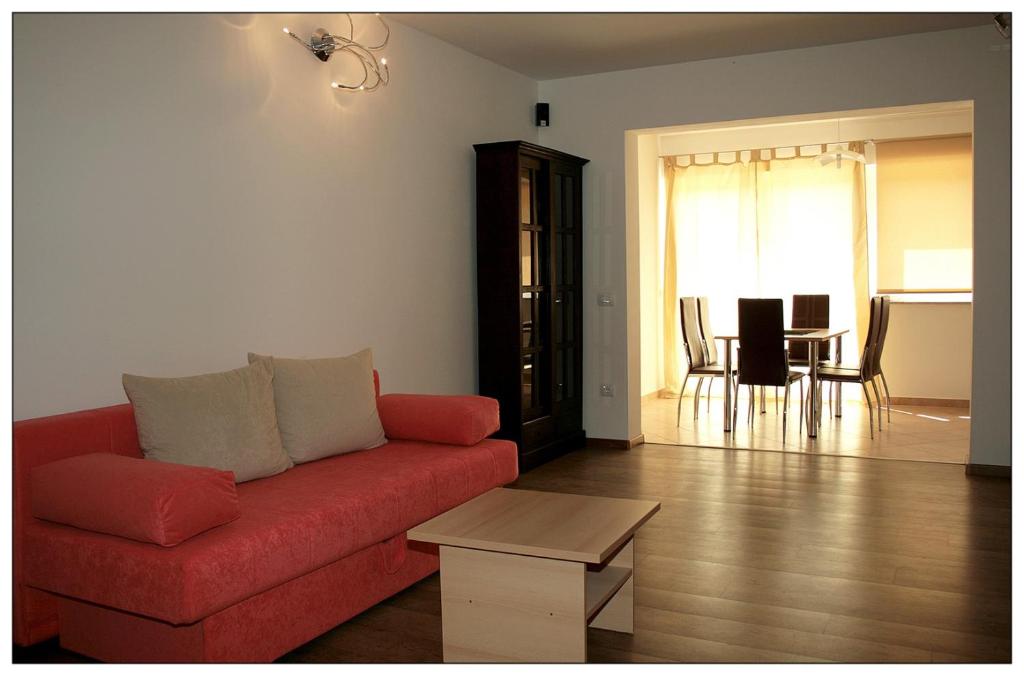 ein Wohnzimmer mit einem roten Sofa und einem Tisch in der Unterkunft Fineda Grande Apartments in Poreč