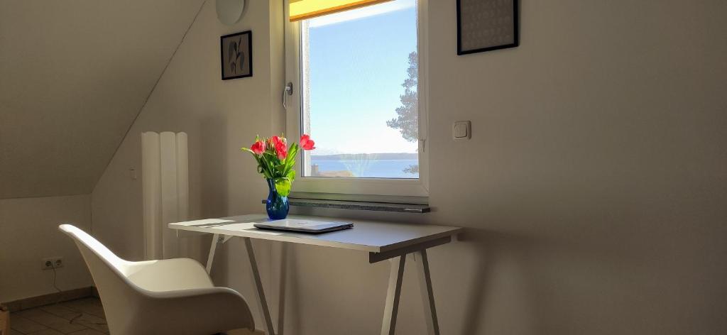 a table with a vase of flowers and a window at Haus Linda in Plau am See