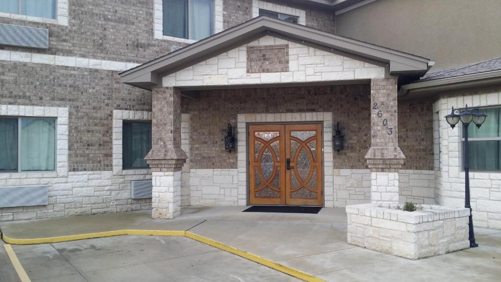 a brick house with a wooden door in front at Premium Inn and Suites in Killeen