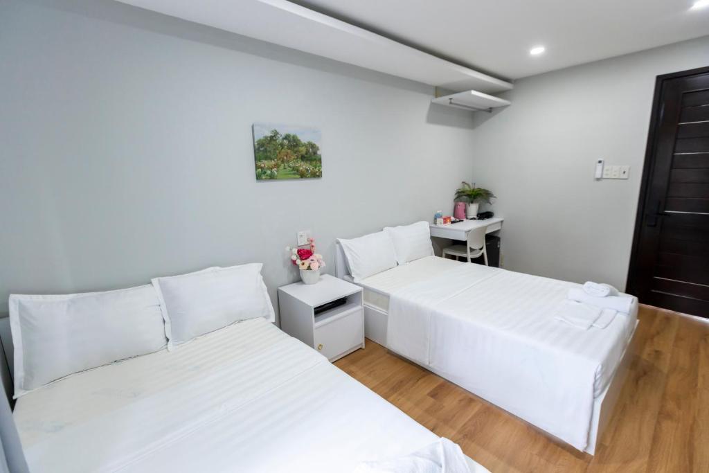Giường trong phòng chung tại Cosmos Hotel Nha Trang by HT