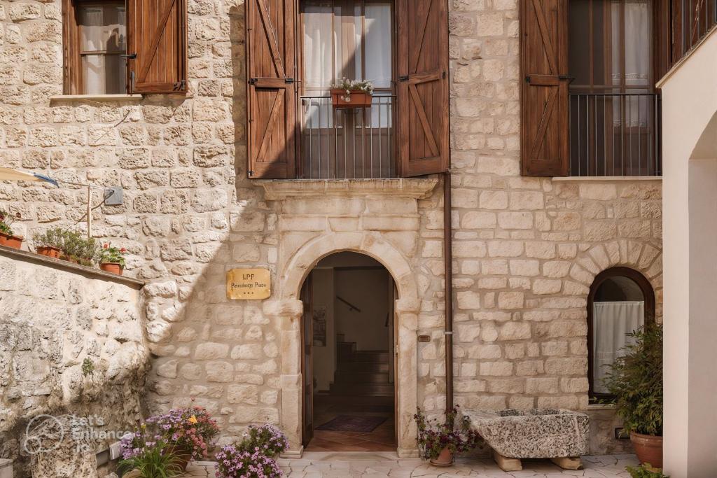 una entrada a un edificio de piedra con ventanas de madera en Hotel Residenza Petra, en Petralia Soprana