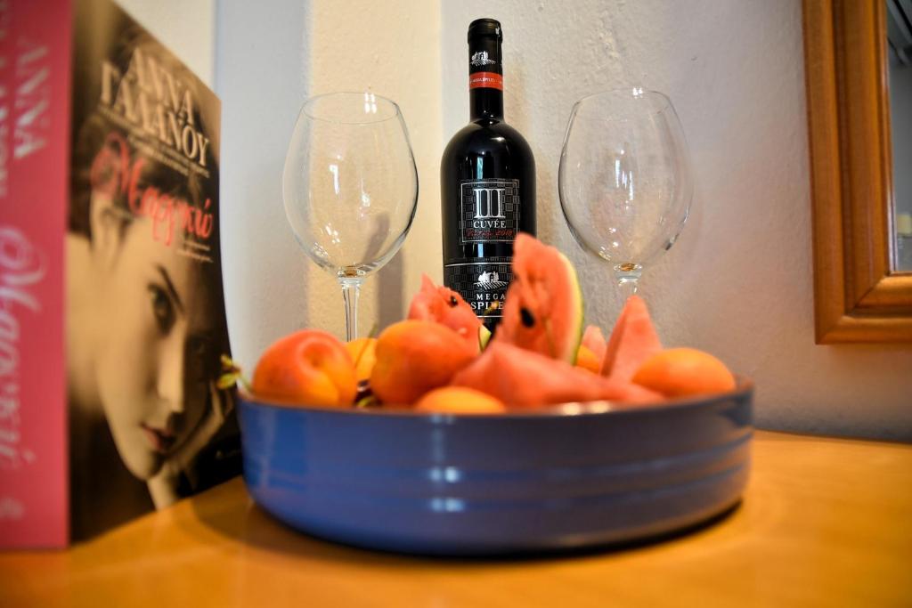 a bottle of wine and two wine glasses on a table at Aristotelis Hotel in Stavros