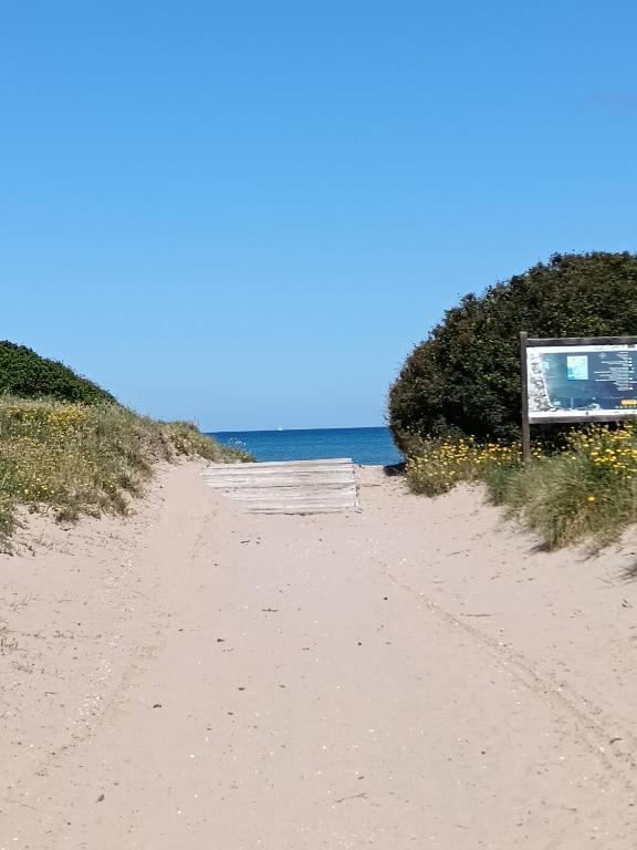 un chemin de terre menant à l'océan sur une plage dans l'établissement Studio Bord de Mer, à Hyères