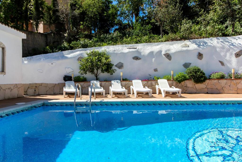 una piscina con tumbonas y un grupo en Villa Natalia C101, en Lloret de Mar