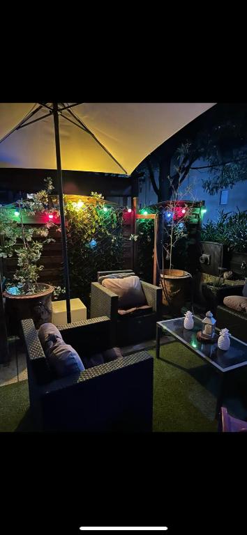 un salon avec des canapés, des tables et un parasol dans l'établissement appartement climatisé, à Avignon