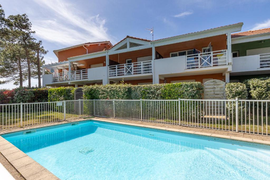 une maison avec piscine devant un immeuble dans l'établissement Appartement Fred, à Moliets-et-Maa