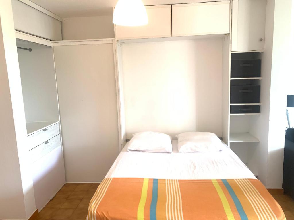 a small bedroom with a bed and white cabinets at Bel appartement situé idéalement in Schœlcher