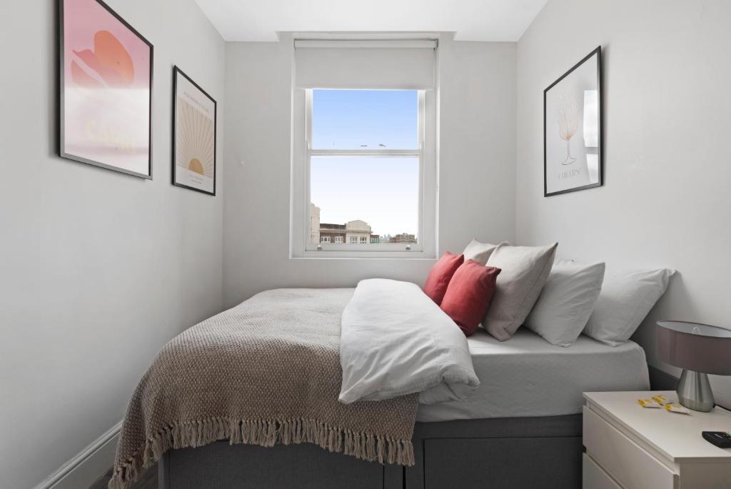 a bedroom with a bed with pillows and a window at Studio 6- Archway Station in London