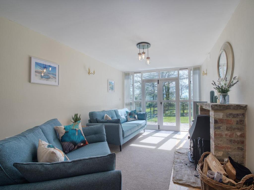 uma sala de estar com dois sofás azuis e uma lareira em 3 Bed in Abbotsbury 92415 em Frome Vauchurch