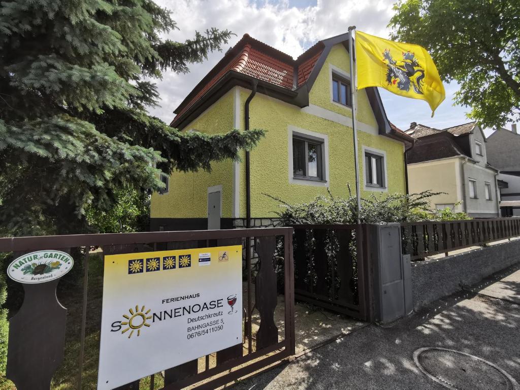 ein gelbes Haus mit einem Schild davor in der Unterkunft Sonnenoase in Deutschkreutz