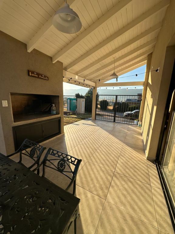 eine überdachte Terrasse mit Tisch und Kamin in der Unterkunft villa marina in Villa General Belgrano