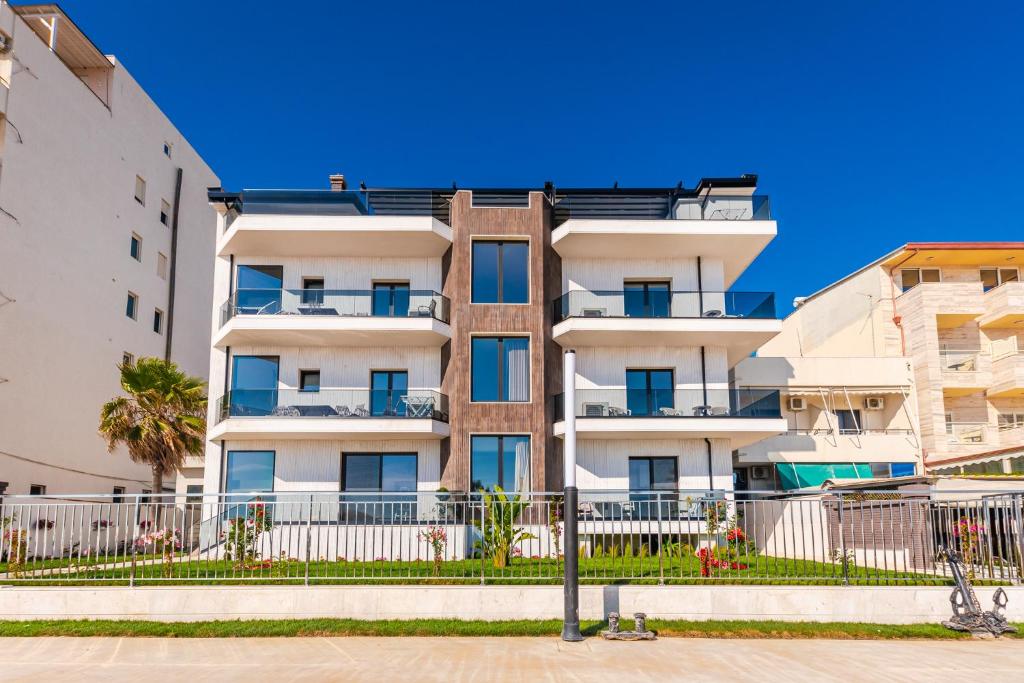 un immeuble d'appartements avec une clôture devant lui dans l'établissement Sea View Apartments ELDO, à Durrës