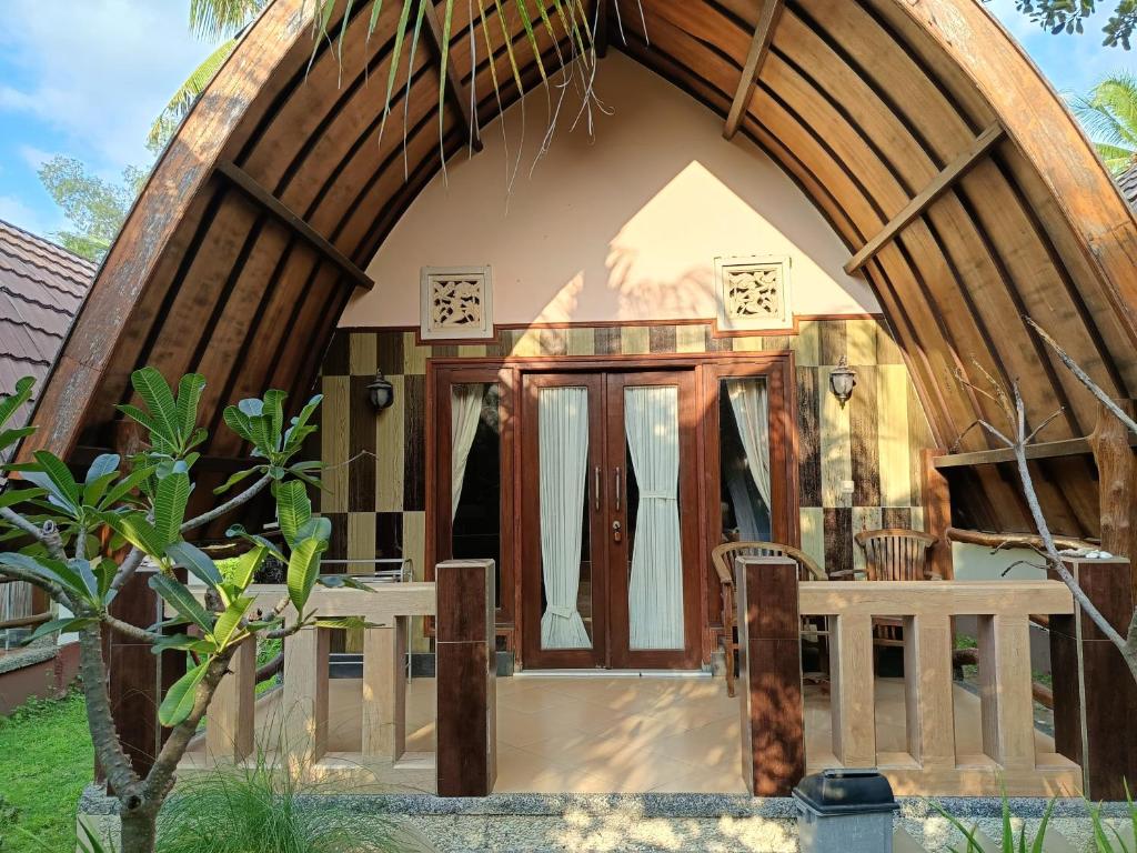 a small house with a large arched doorway at Noby Gili Cottages in Gili Meno