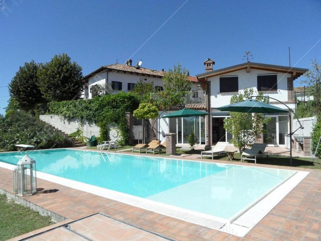 a large swimming pool in front of a house at Salera Alta in Castagnole Lanze