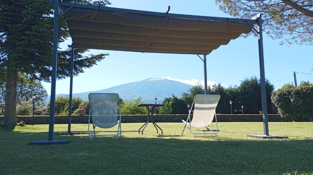 due sedie e un tavolo sotto un baldacchino nell'erba di Nero Etna a Bronte