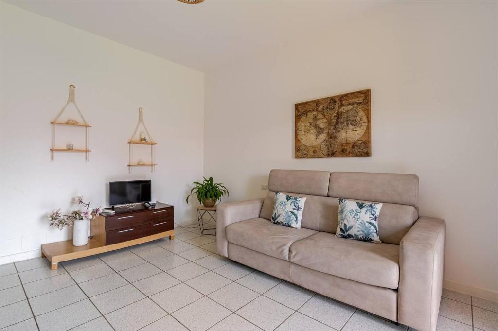 a living room with a couch and a tv at La Casetta-10 min Aeroporto e spiaggia in Fiumicino