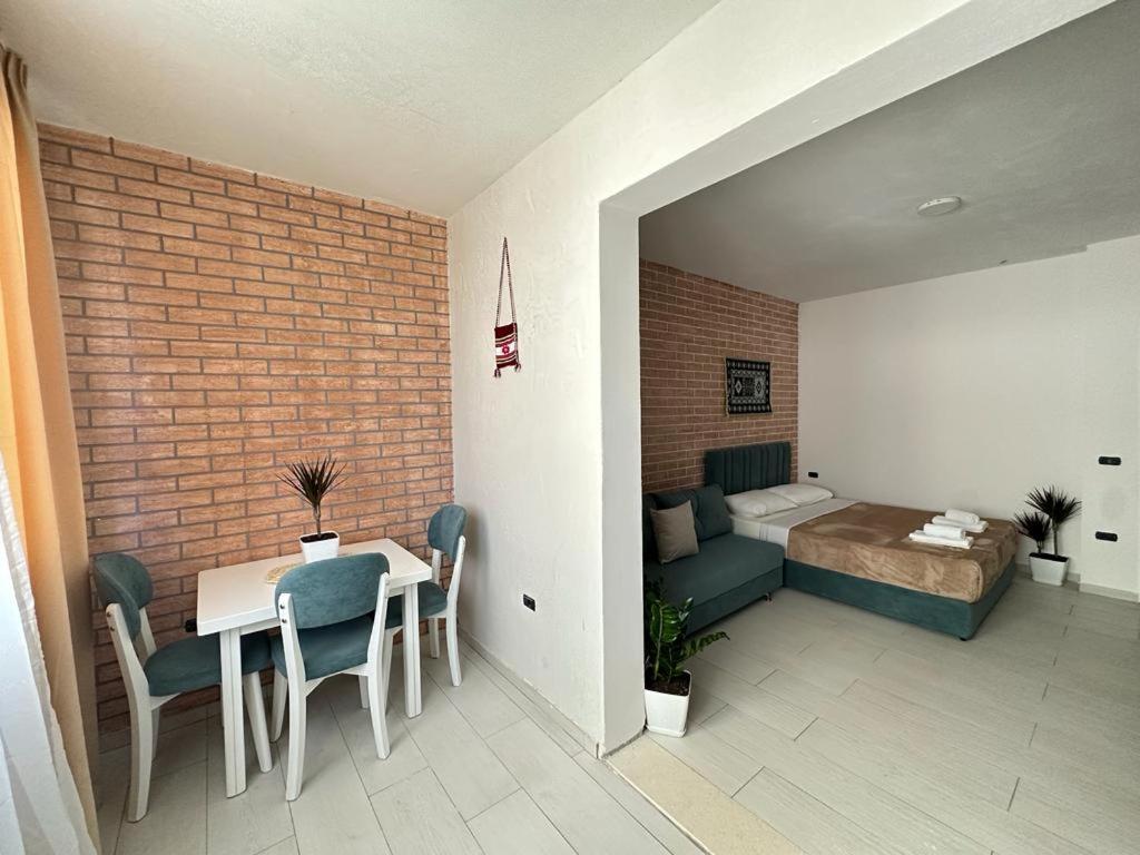 ein Zimmer mit Tisch und Stühlen und ein Schlafzimmer in der Unterkunft TreA Accomodations - Suite port in Vlorë