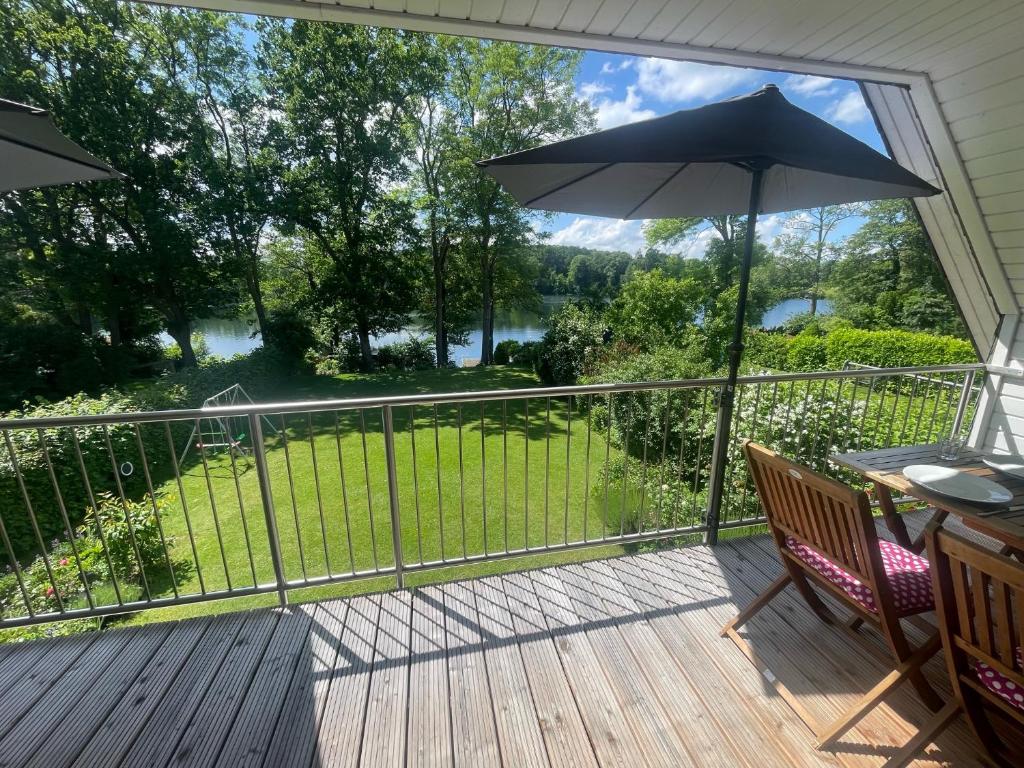 Un balcón con una sombrilla y una mesa y sillas. en Ferienwohnung Plön am See, en Plön