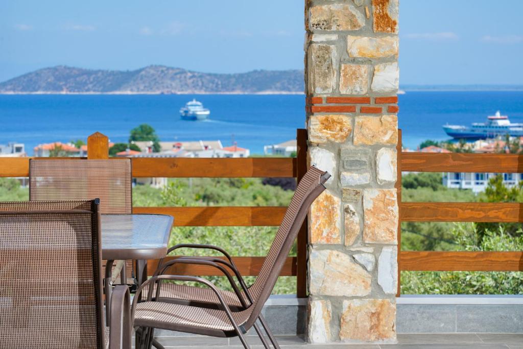 タソスにあるHelicon Luxury Villasのテーブルと椅子、海の景色を望むバルコニー