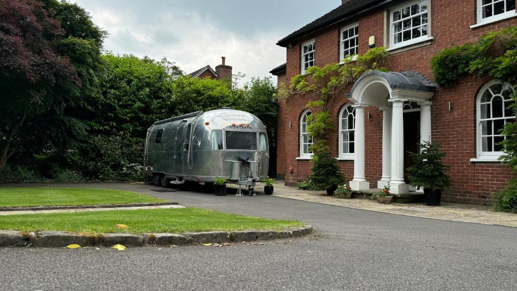 a green trailer parked in front of a house at Airstream Experience in Knutsford