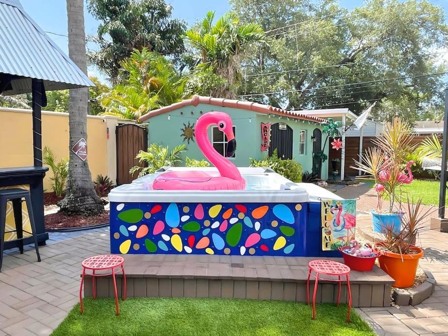 Różowy pomnik flaminga siedzący na lodówce w obiekcie Fun Getaway: Hot Tub, Tiki Bar, Arcade Room w mieście Hollywood