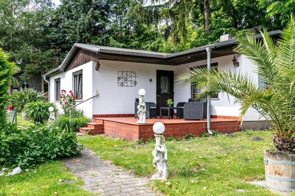 a small white house with a porch at Haus am See in Königs Wusterhausen
