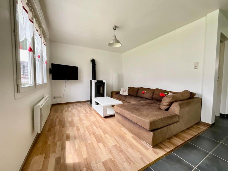 un salon avec un canapé et une télévision à écran plat dans l'établissement L'Appart du Lac de Gérardmer - Beau & spacieux, à Gérardmer