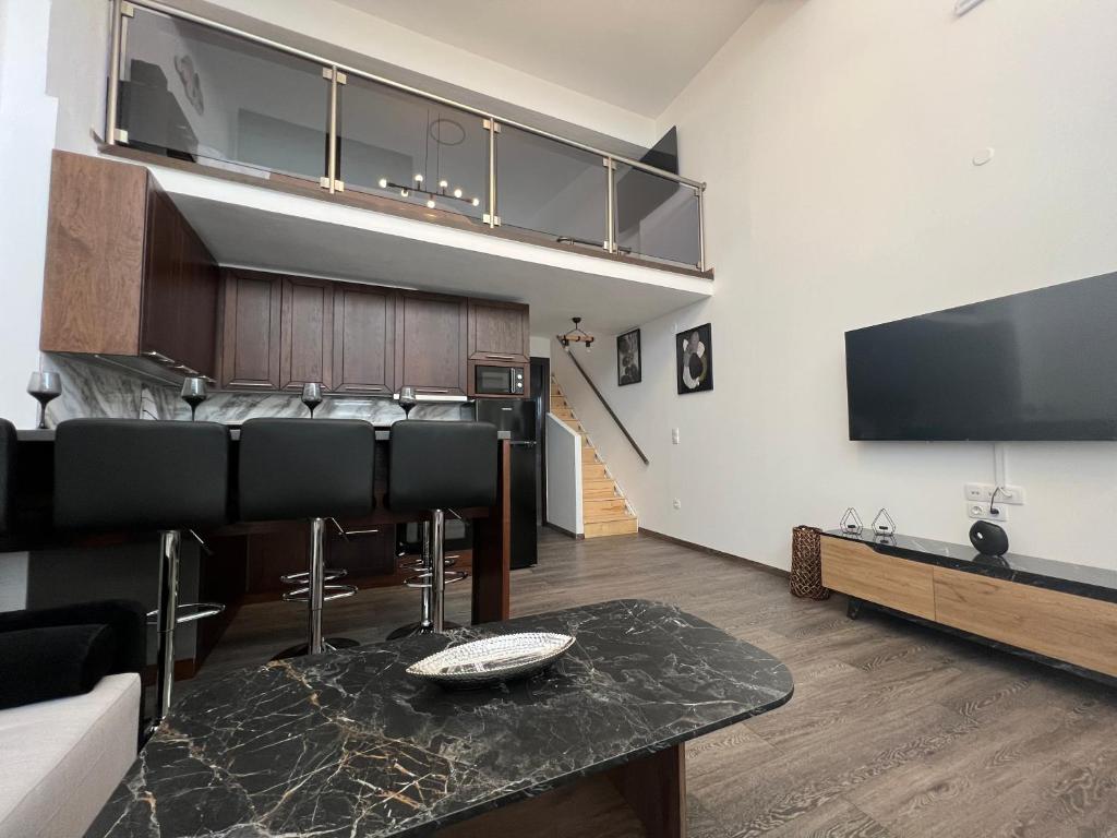 a living room with a table and a tv at Elegant Loft 2 in Alexandroupoli