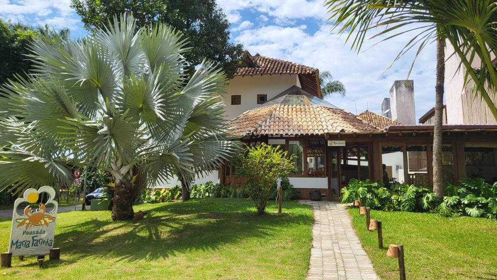 una casa con palmeras y un cartel delante en Pousada Maria Farinha, en Itacaré