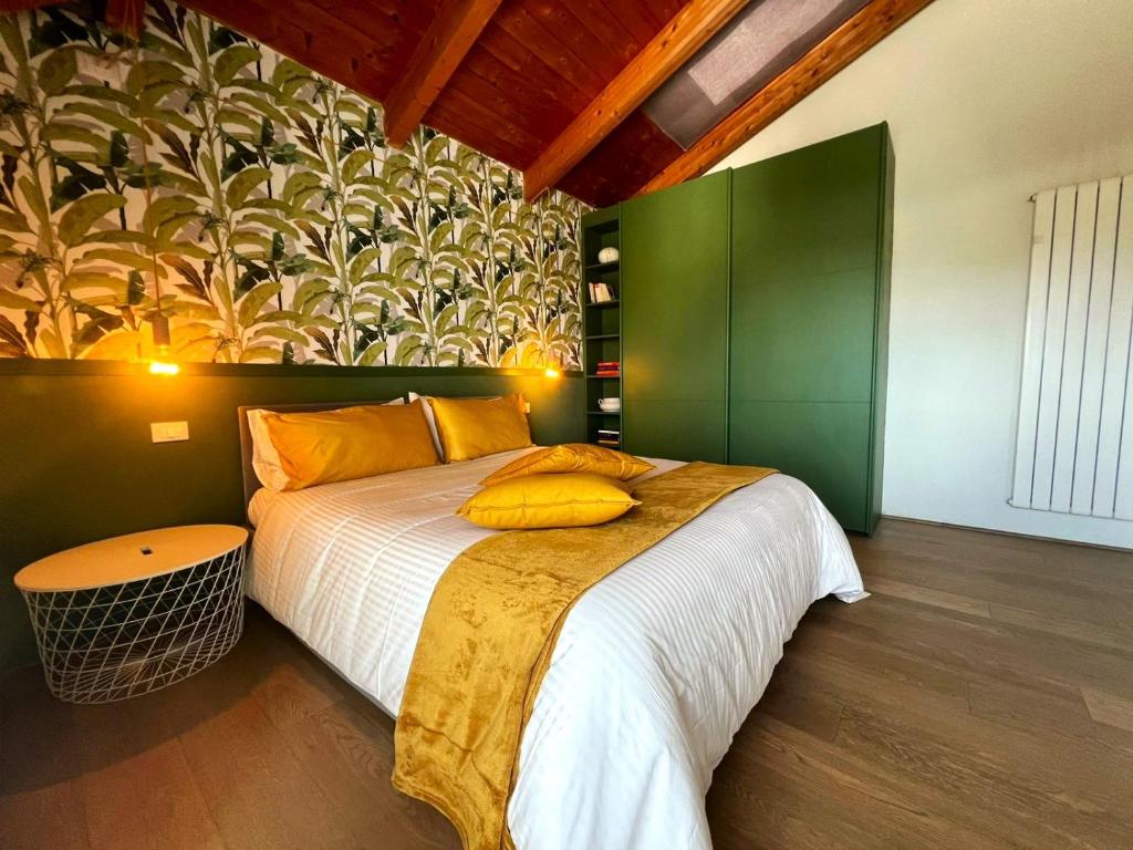 a bedroom with a large bed with yellow pillows on it at Jungle in Lucca in Capannori