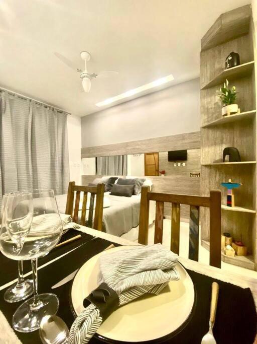a dining room table with a glass of wine and a room at Studio Luxury Copa - beira mar in Rio de Janeiro