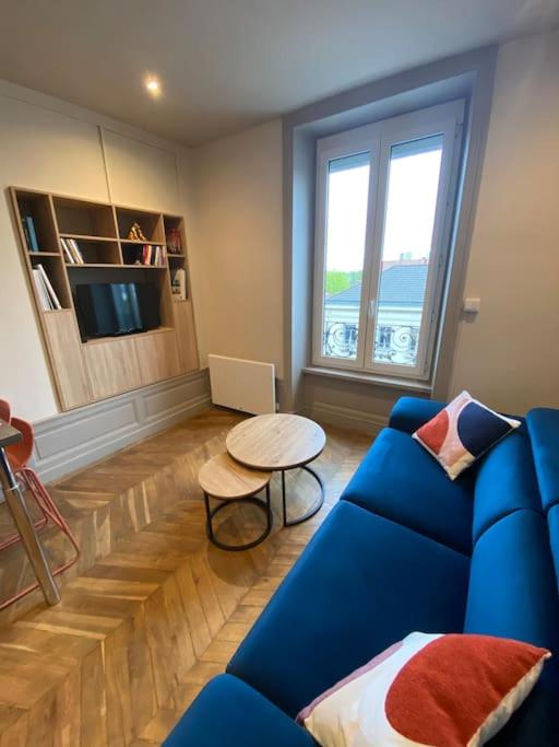 un salon avec un canapé bleu et une table dans l'établissement Terra Élégant appartement Gare SNCF 4p, à Clermont-Ferrand