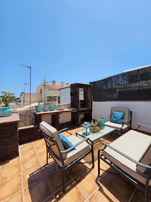 un patio con 2 sillas y una mesa en el techo en Pedregalejo Beach House, en Málaga