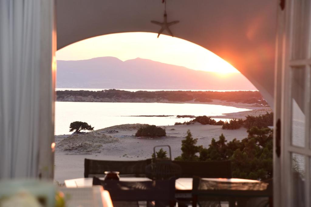 uma vista para o pôr-do-sol a partir de um quarto com uma janela em Paradise Pirgaki Naxos em Agiassos