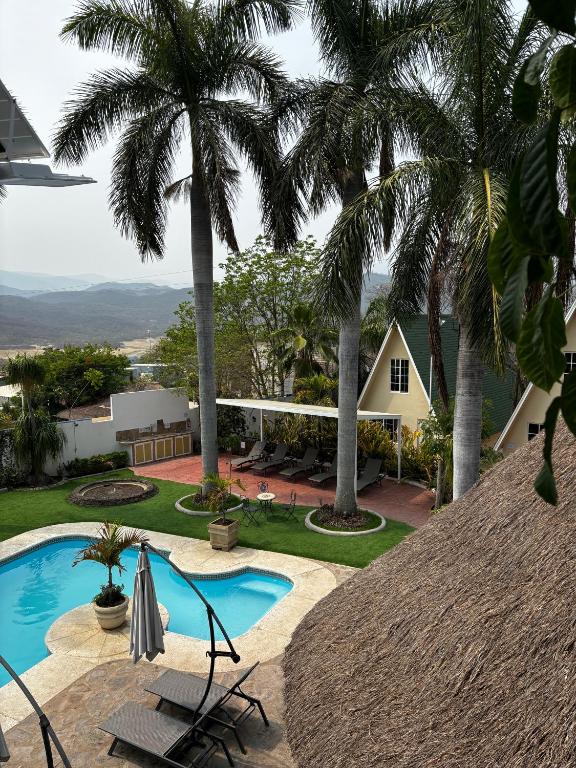 a resort with a pool and palm trees at VILLAS EL ENCANTO in Jalpan de Serra