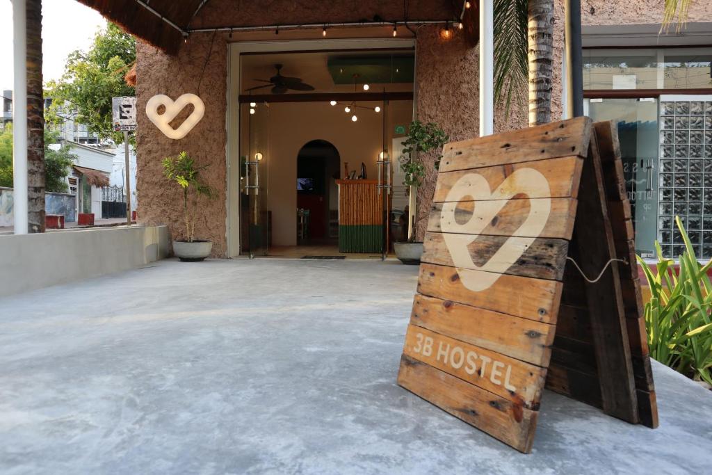 a wooden door with a sign that reads be house at 3B Wellness Hostel in Playa del Carmen